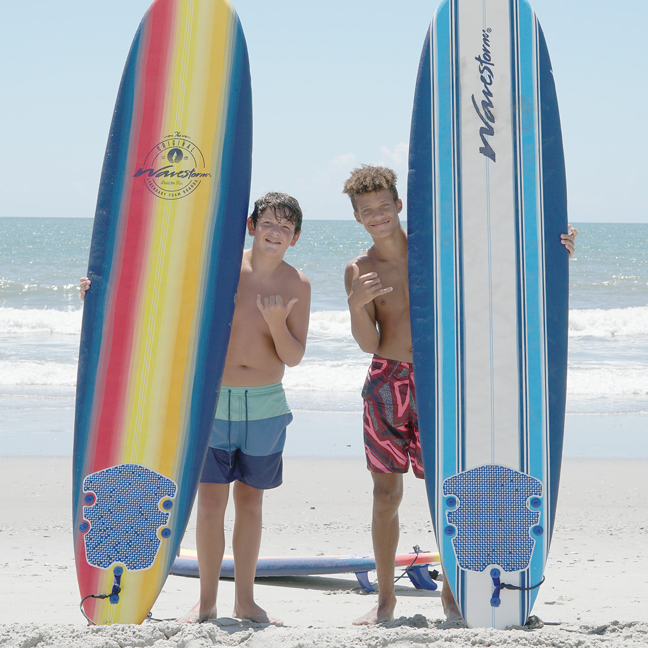 two boys holding surfboards at camp in myrtle beach