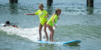 Participants catching small waves during a Myrtle Beach surf class