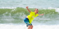 Student learning to surf during a Myrtle Beach surf school lesson