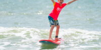 surf school participant riding waves in Myrtle Beach