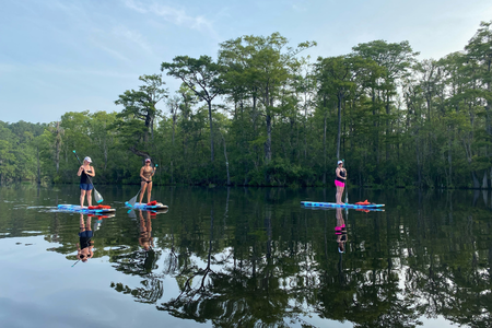Three people stand-up paddleboarding in Myrtle Beach